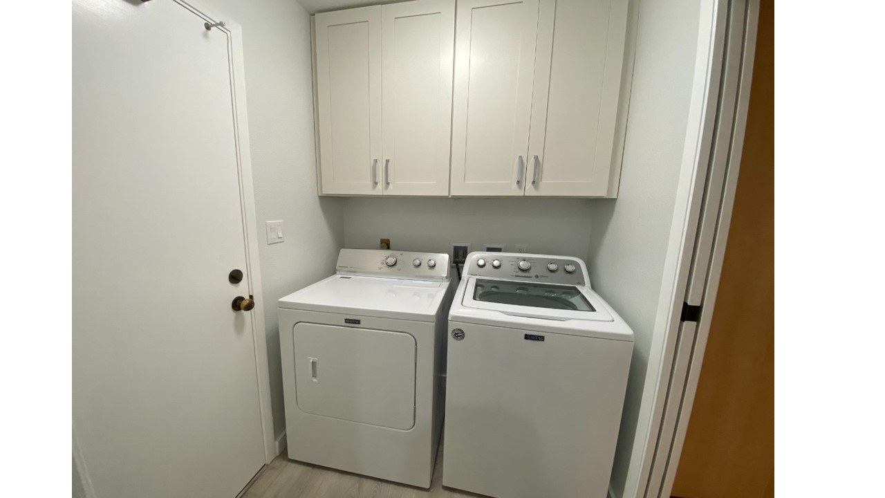 A small laundry room with a washer and dryer.